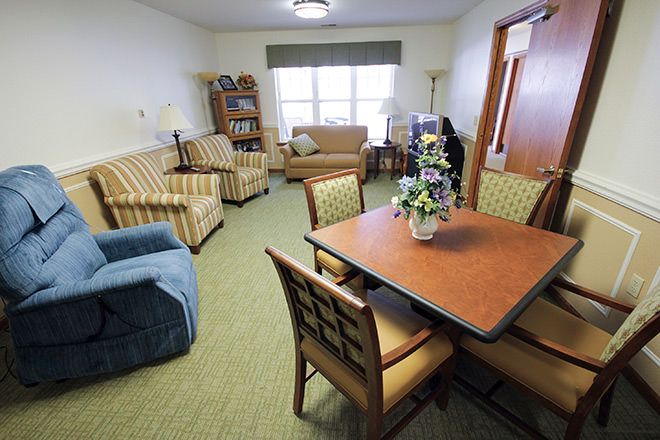 A cozy living room with various seating options and a central table.