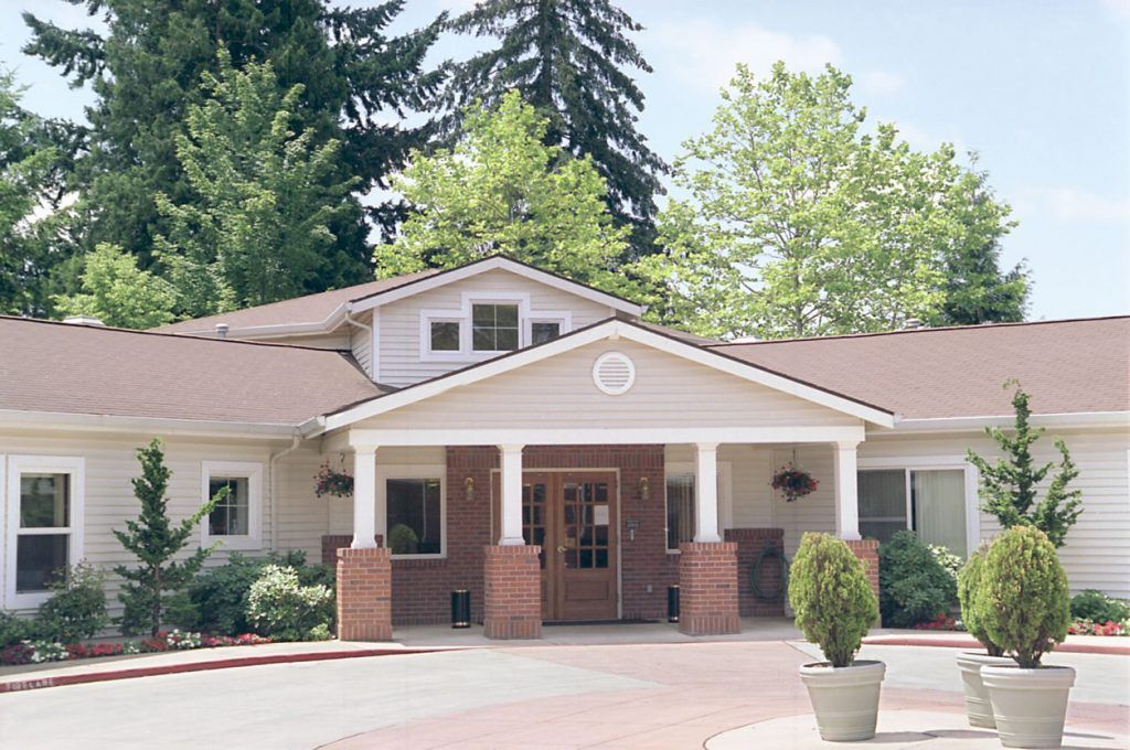 A residential building with a welcoming entrance surrounded by trees.