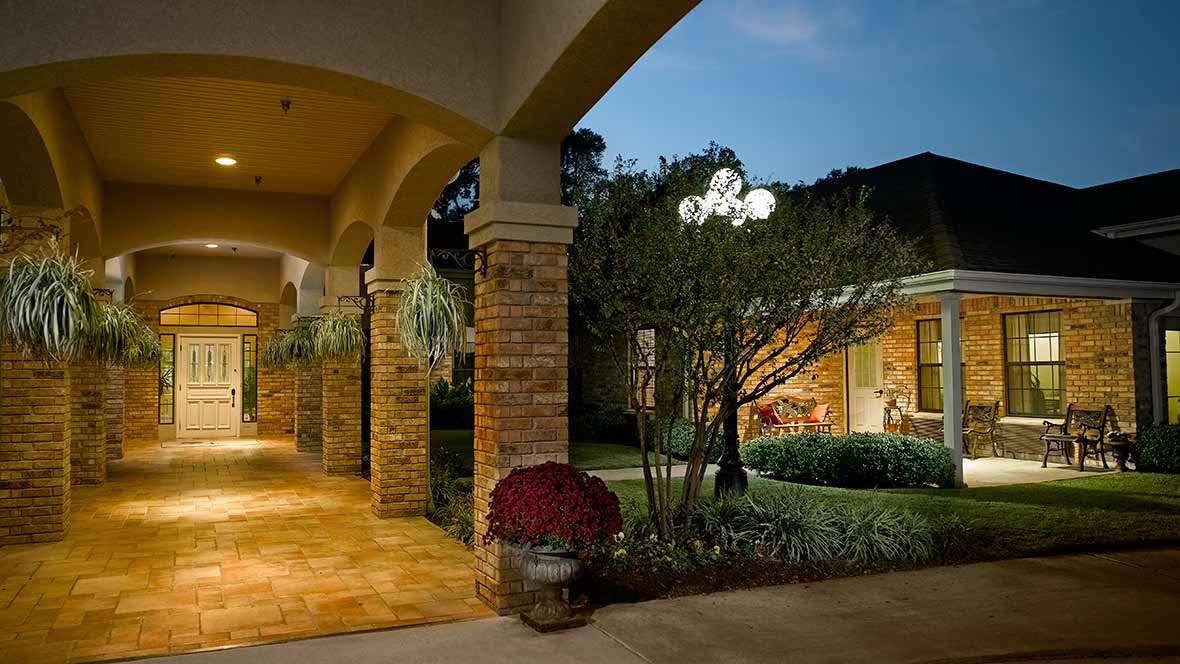 A beautifully lit building with an outdoor garden in the evening.
