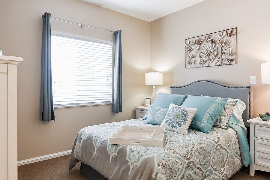 A cozy bedroom with a neatly made bed, soft pillows, and gentle lighting.