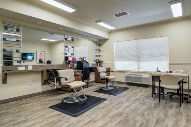 A well-lit barber shop interior with two haircut stations and mirrors.