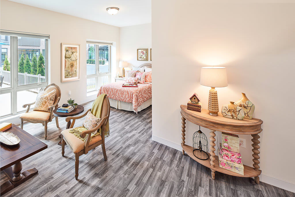 A cozy bedroom with stylish interior design featuring wooden flooring, natural light, and elegant furniture.