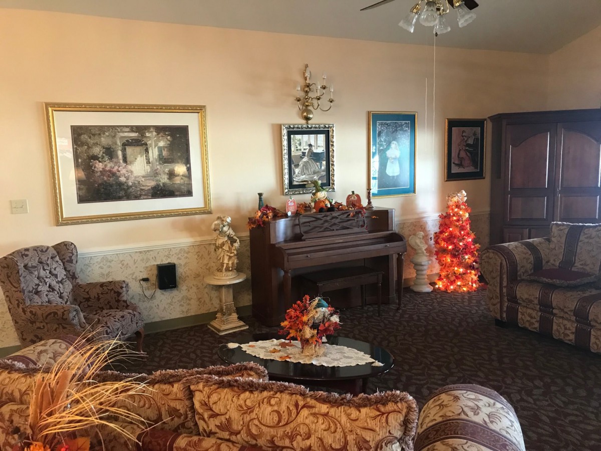 A cozy living room adorned with a piano, holiday decorations, and elegant furniture.