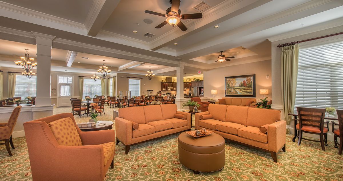 A spacious living room with comfortable seating and warm lighting.
