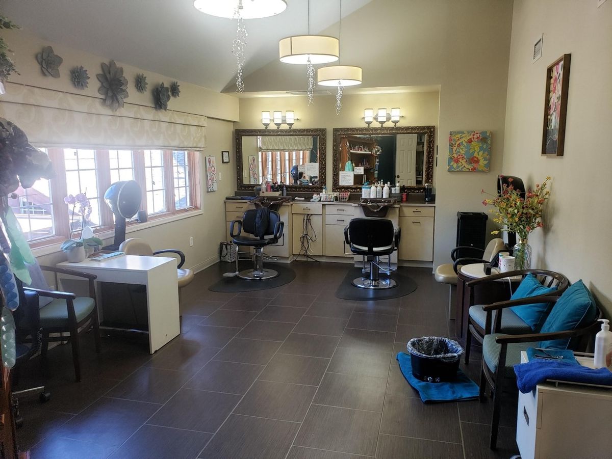 Spacious salon interior with styling stations and large windows.