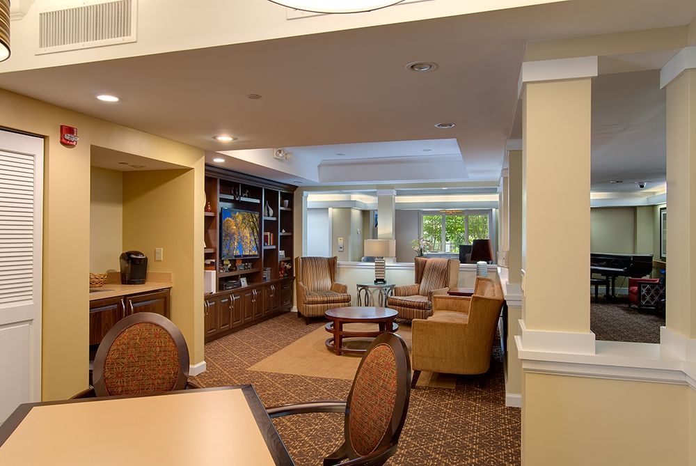 A cozy living room with comfortable seating, bookshelves, and warm lighting.