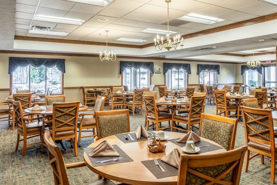 An elegant dining room with neatly set tables and wooden chairs.