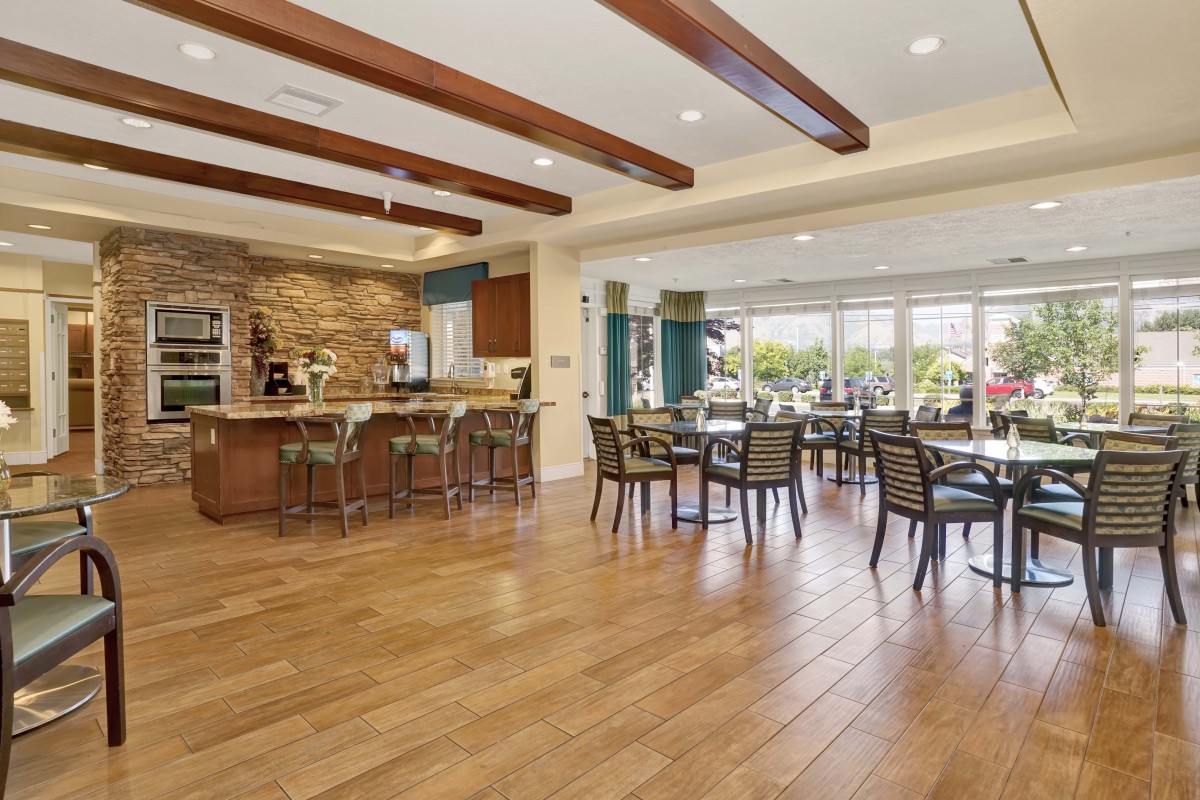 A modern dining area with wooden flooring, showcasing an open and inviting space with ample natural light.
