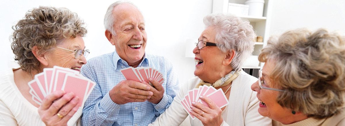 A joyful elderly couple enjoying a game of cards together.