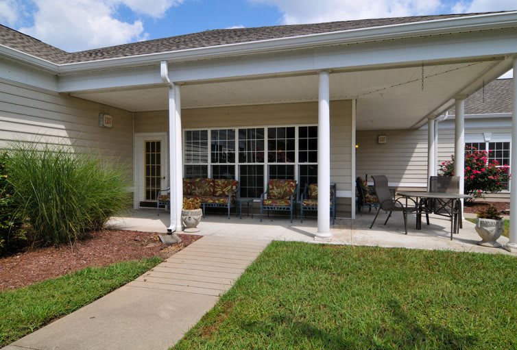 A cozy patio with outdoor seating and a well-maintained lawn.