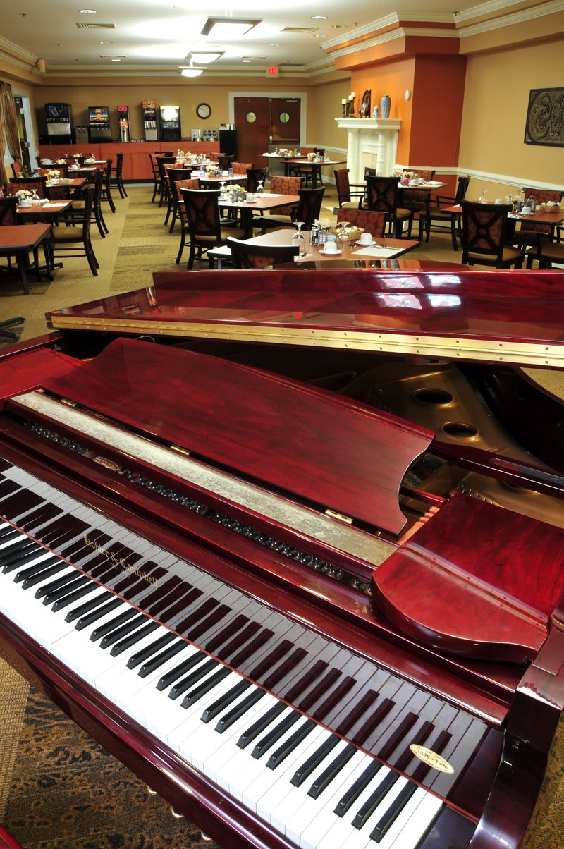 A grand piano in the dining area of a restaurant.