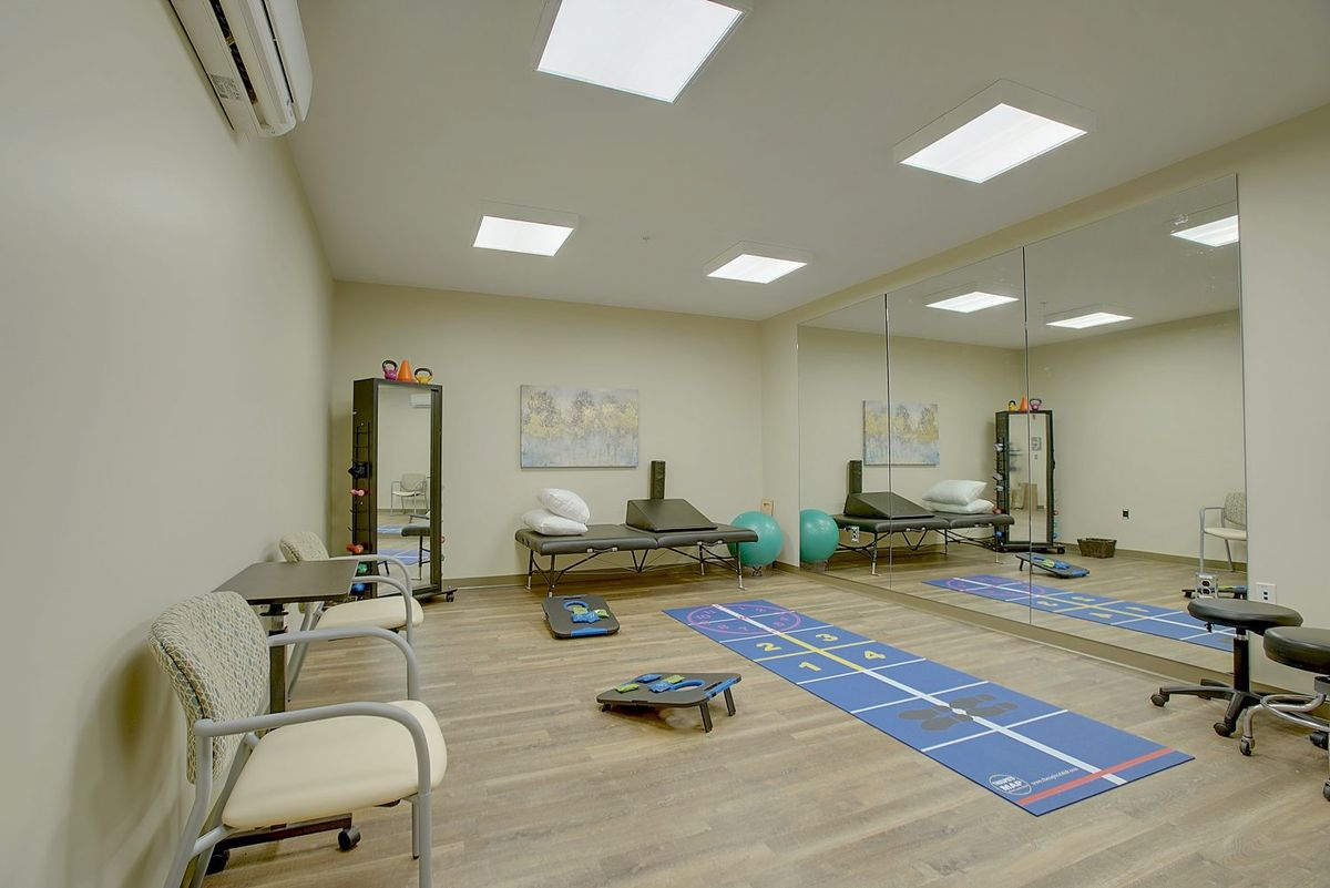A well-equipped exercise room featuring yoga mats and fitness equipment.