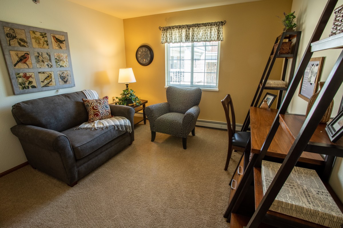 Cozy living room with a sofa, armchair, and warm lighting.