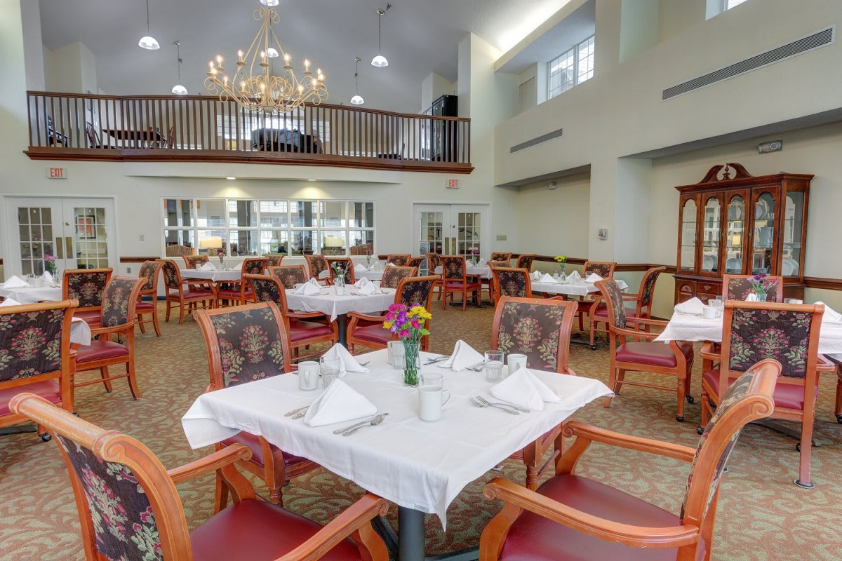 A well-decorated dining area with neatly arranged tables and a chandelier.