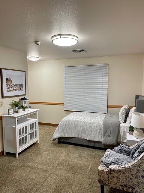 A tidy, minimalist bedroom with a single bed, nightstand, and decor.