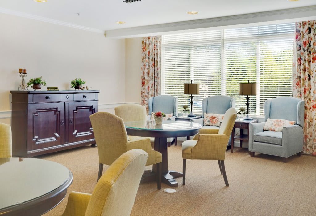 A cozy living room with comfortable chairs and a table set near large windows.