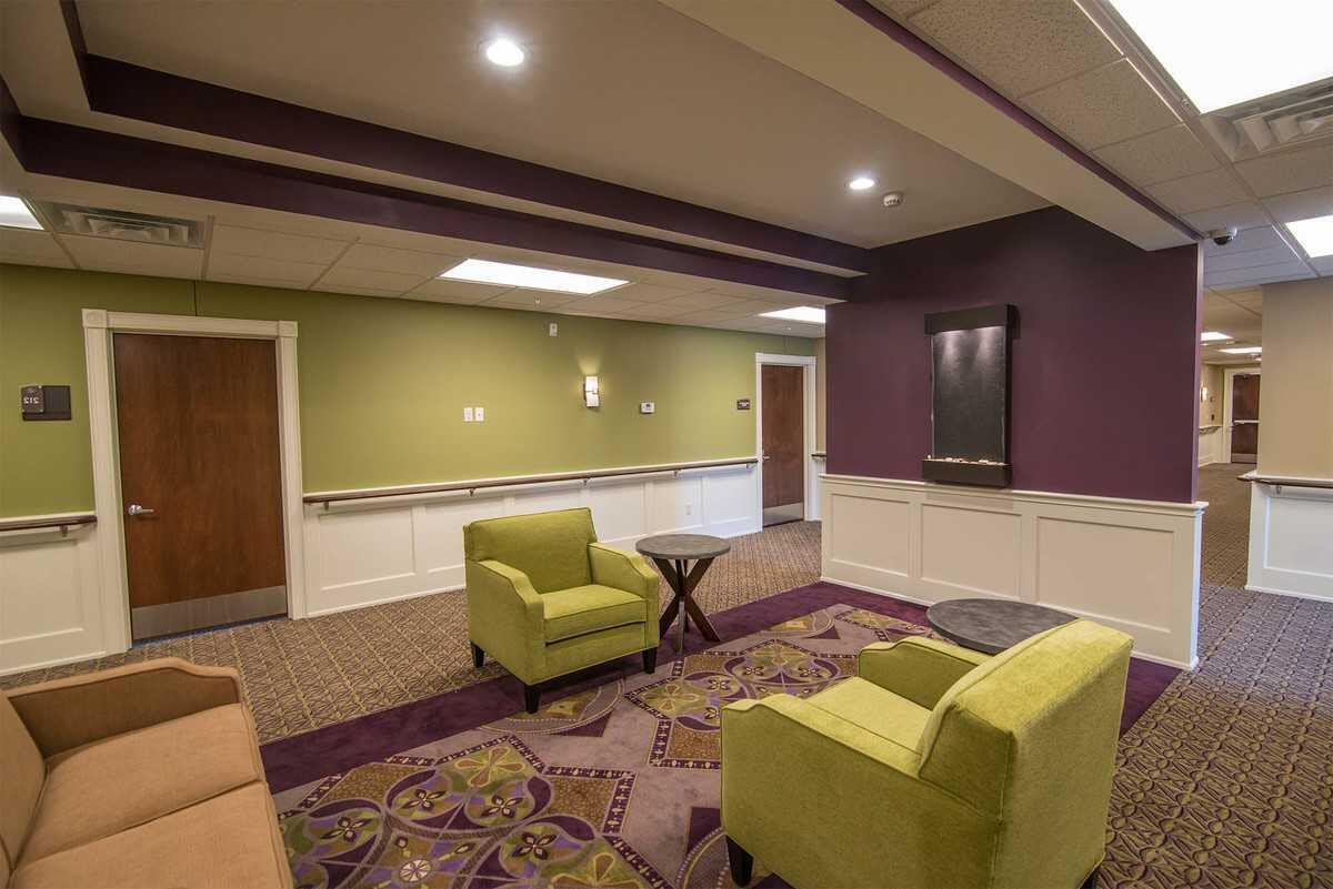 A cozy lounge area with green chairs and vibrant decor.