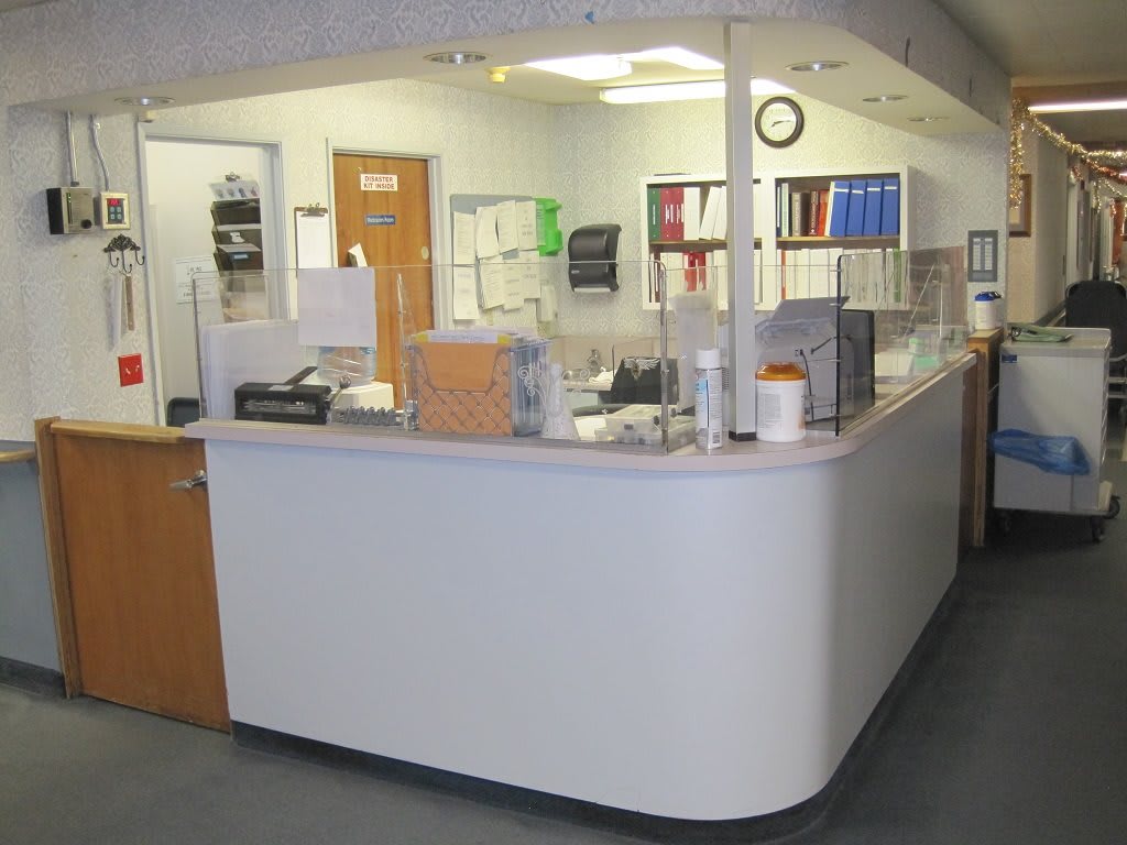 A reception desk area in an office or medical clinic, featuring organized workspaces and office supplies.