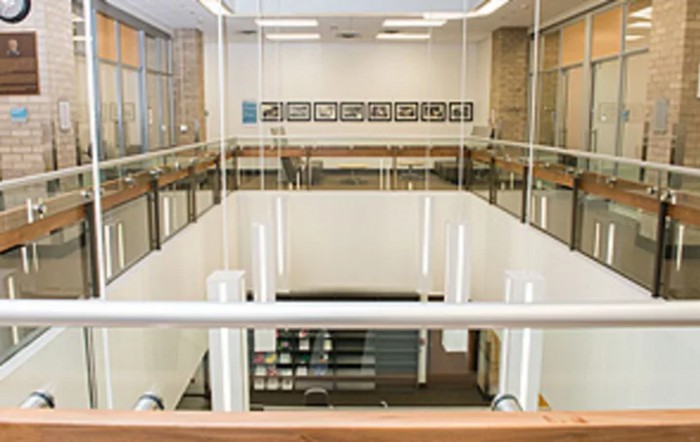 A view of a modern interior with glass walls and a staircase.
