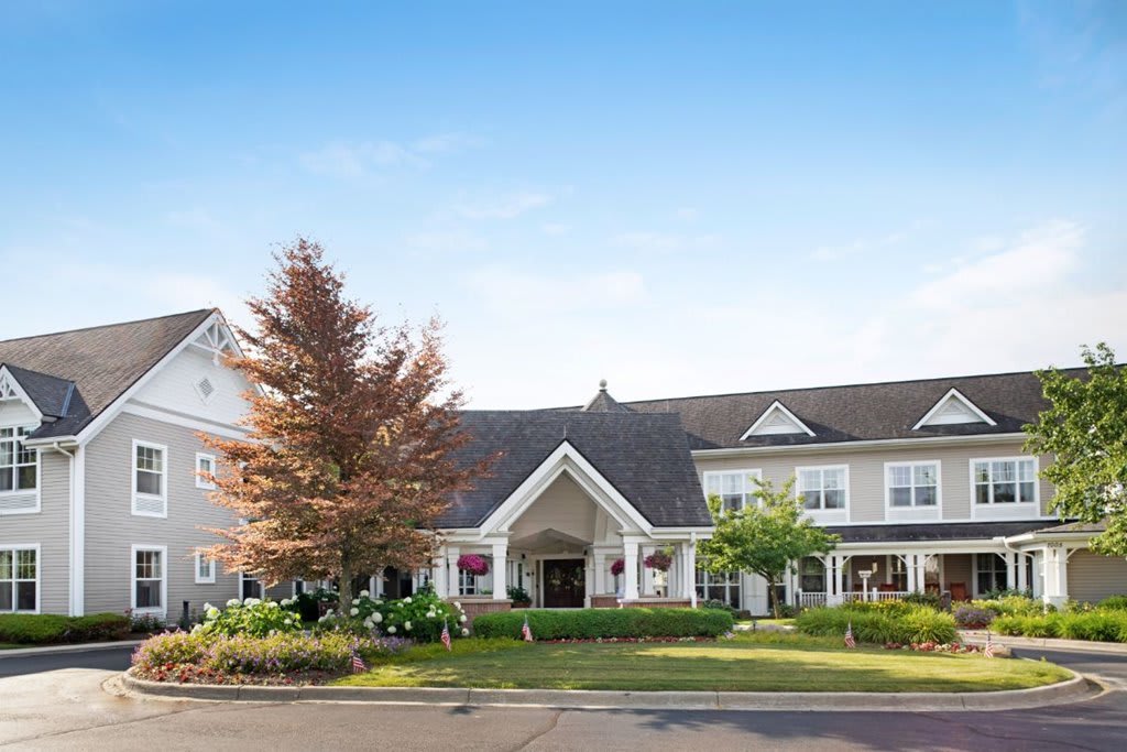 A picturesque residential building with well-maintained landscaping and clear blue sky.