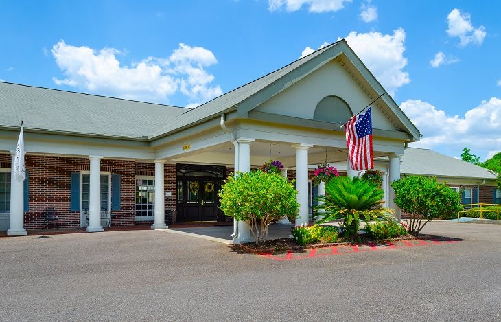 A building with a grand entrance, featuring columns and an American flag.