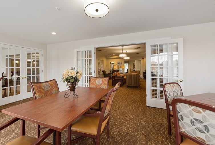 A well-decorated dining room with a wooden table and chairs, featuring elegant lighting and decorative elements.