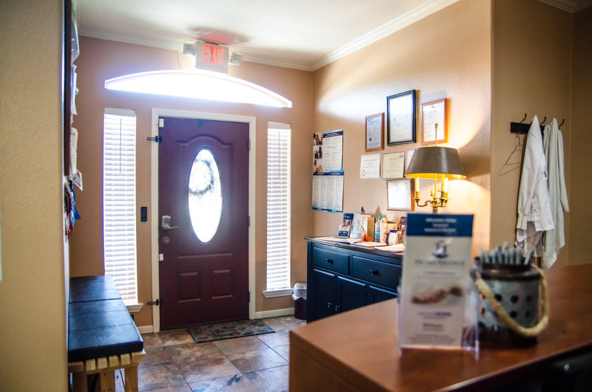 A cozy waiting room with a front door and various decor elements.