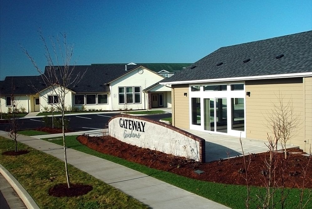 A residential building with a pathway and well-maintained landscaping.