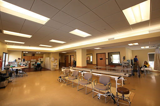 A spacious and well-lit interior of a hospital waiting area with seating arrangements.