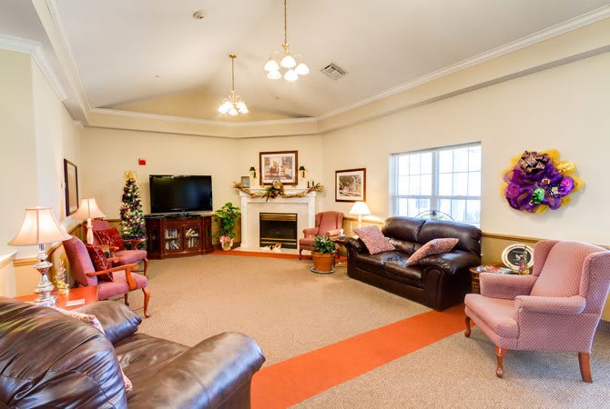 Cozy living room with a television, fireplace, and various seating options.