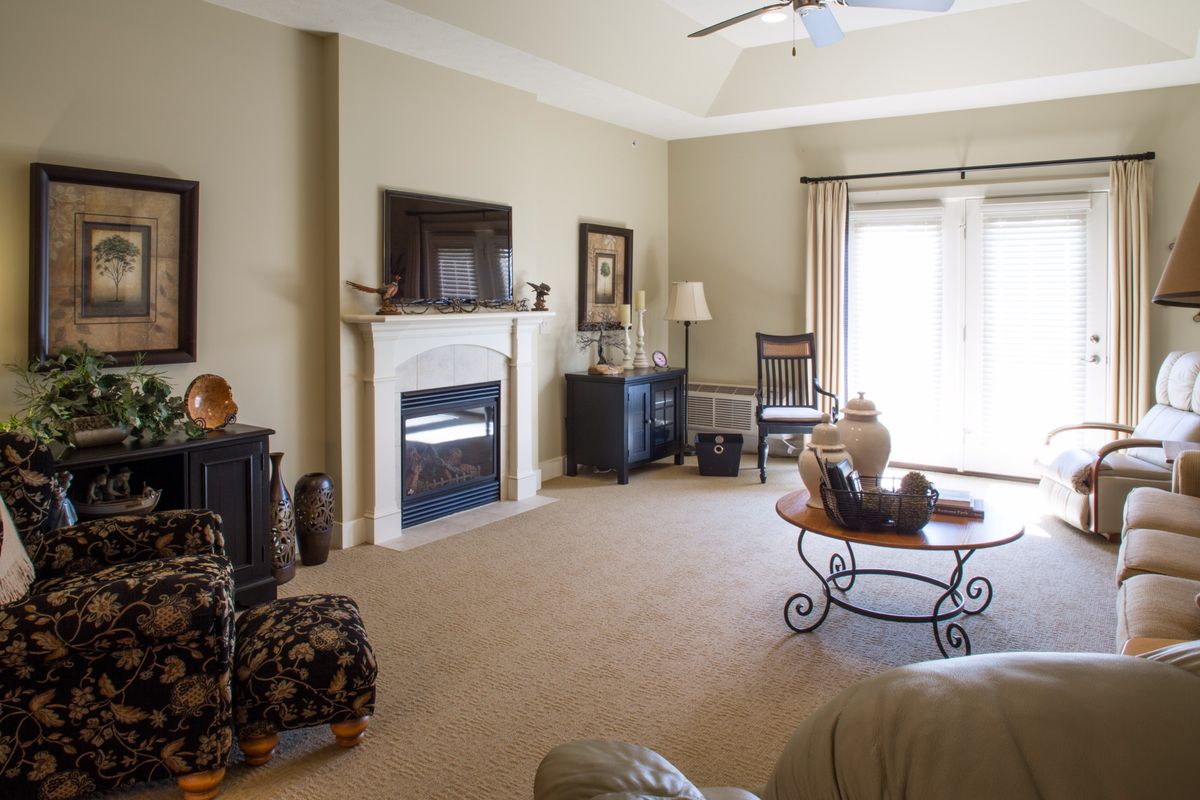 A cozy living room with a fireplace and television, featuring comfortable seating and elegant decor.