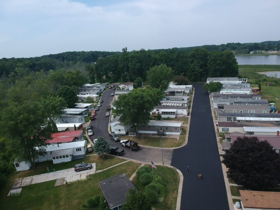 Aerial view of a mobile home community surrounded by trees and roads.