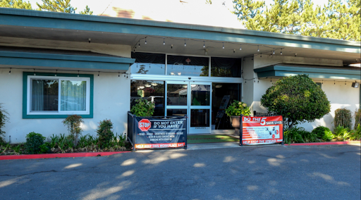 The entrance of a commercial building with decorative signage and landscaping.