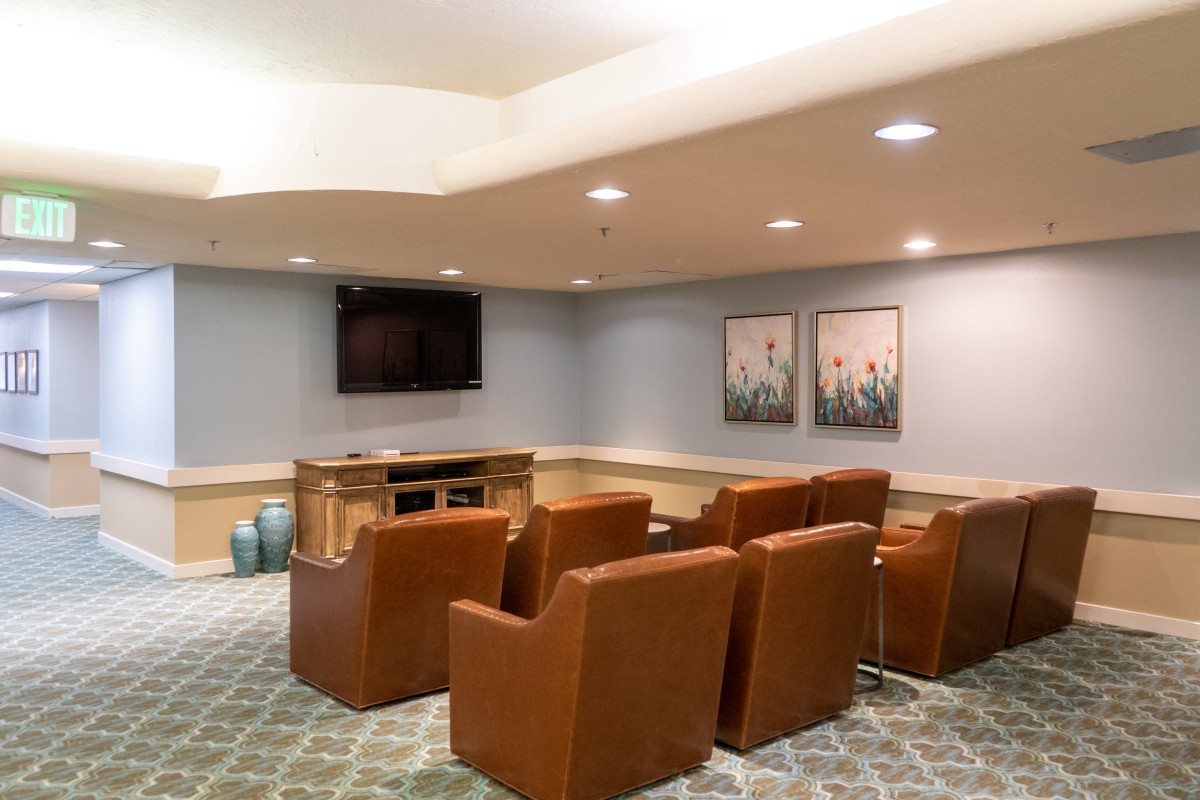 Cozy living room with comfortable armchairs facing a television, complemented by wall art.