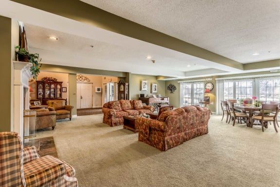 A spacious living room with ample seating, featuring patterned sofas and natural lighting.