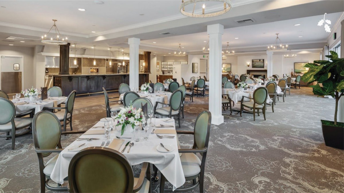 An elegant dining area with neatly arranged tables and floral decorations.