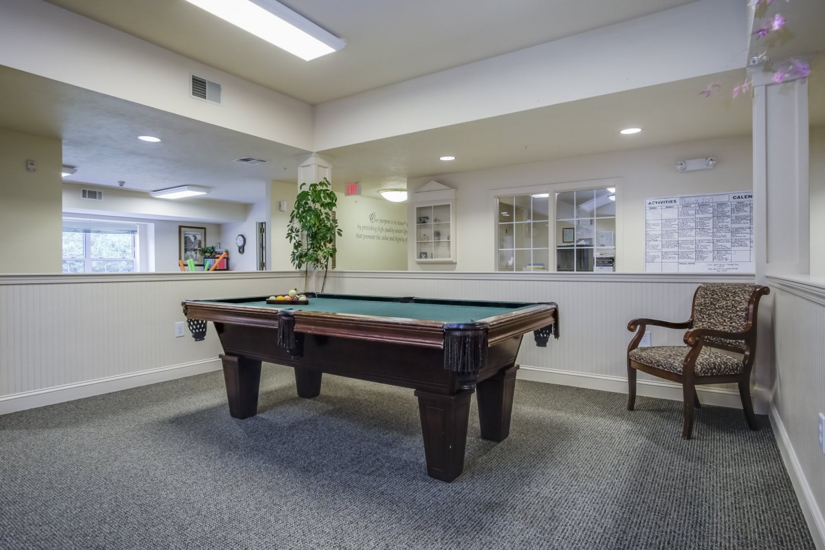 A spacious indoor recreation room featuring a pool table and seating area.