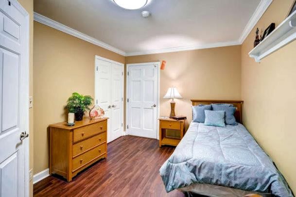 A cozy bedroom with wooden furniture and a well-made bed.