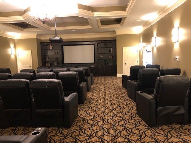 A luxurious home theater setup with comfortable seating and a large projector screen.