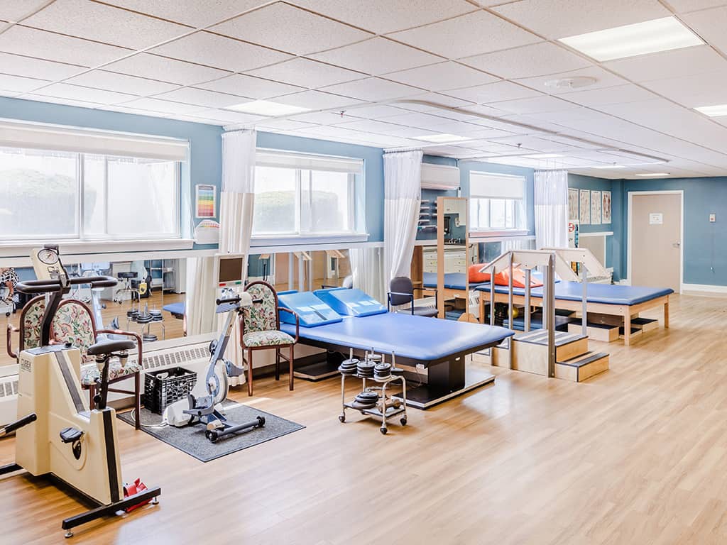 A physical therapy clinic equipped with various exercise machines and therapy beds.