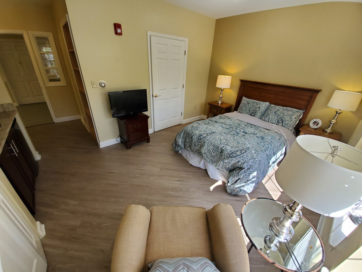 A cozy bedroom with a bed, television, and comfortable seating.