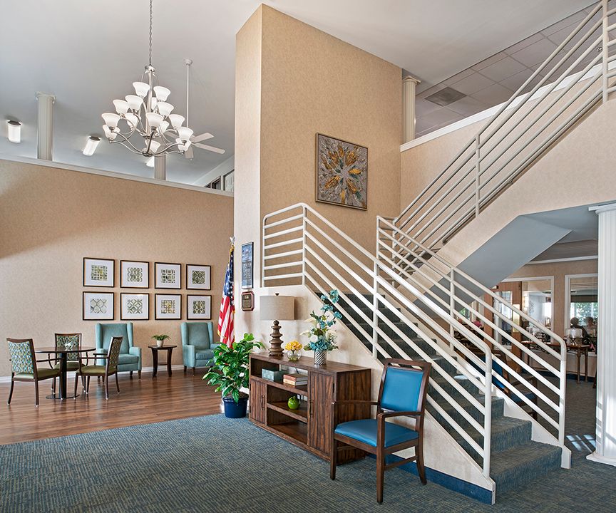 A modern lobby with a staircase, seating area, and decorative elements.