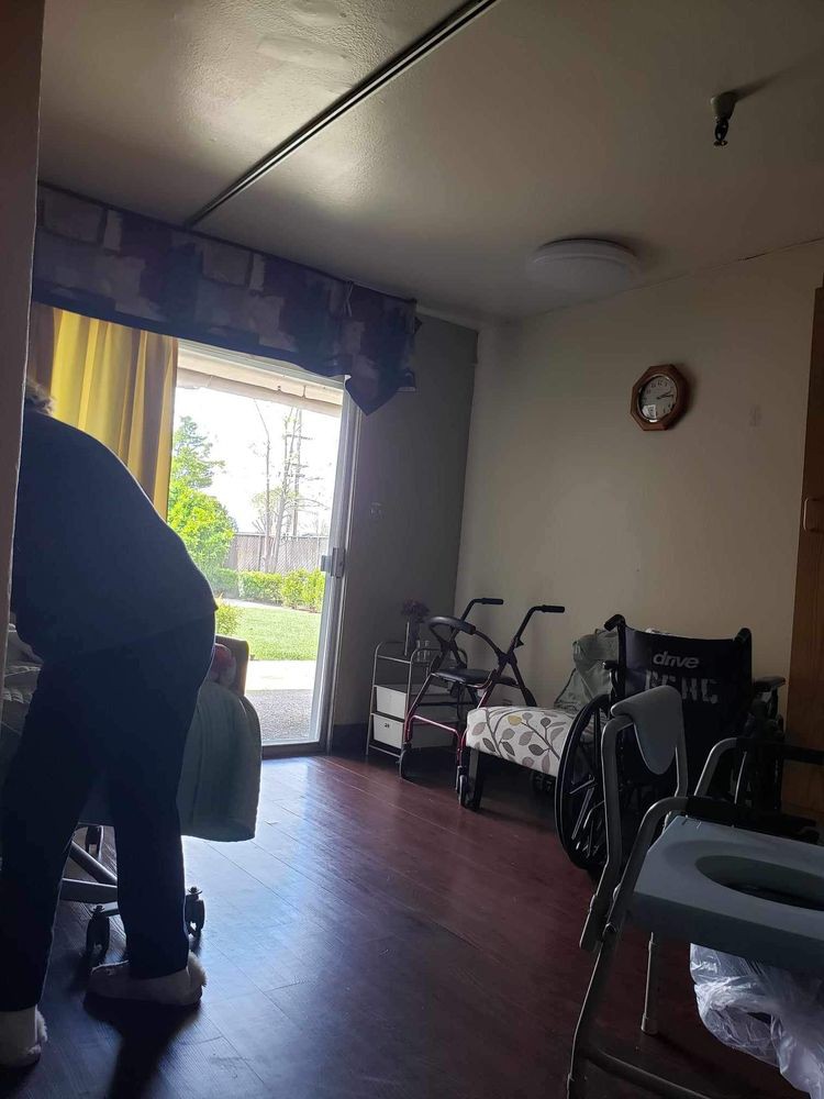 A room with a wheelchair and walker near the window.