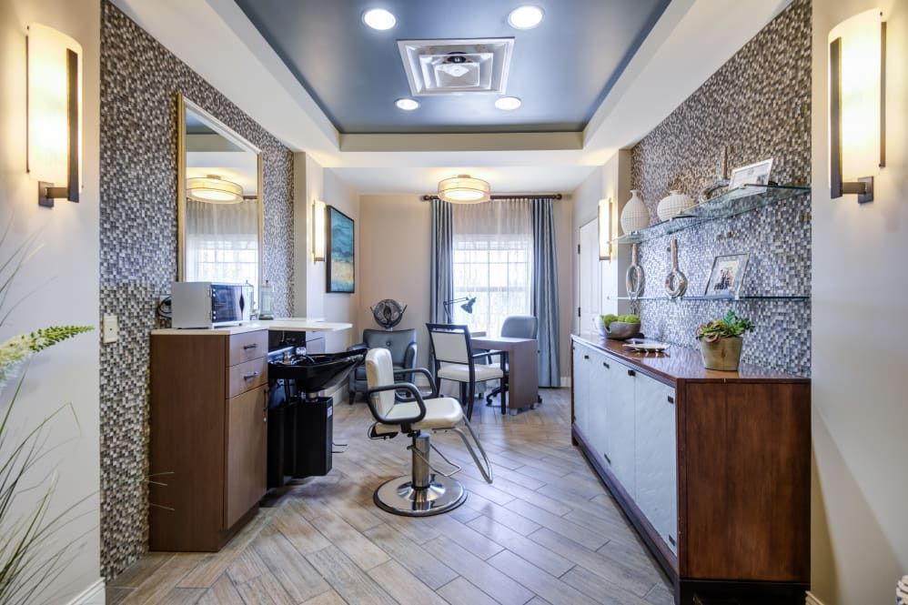 Modern hair salon interior with a styling chair, mirrors, and decorative elements.
