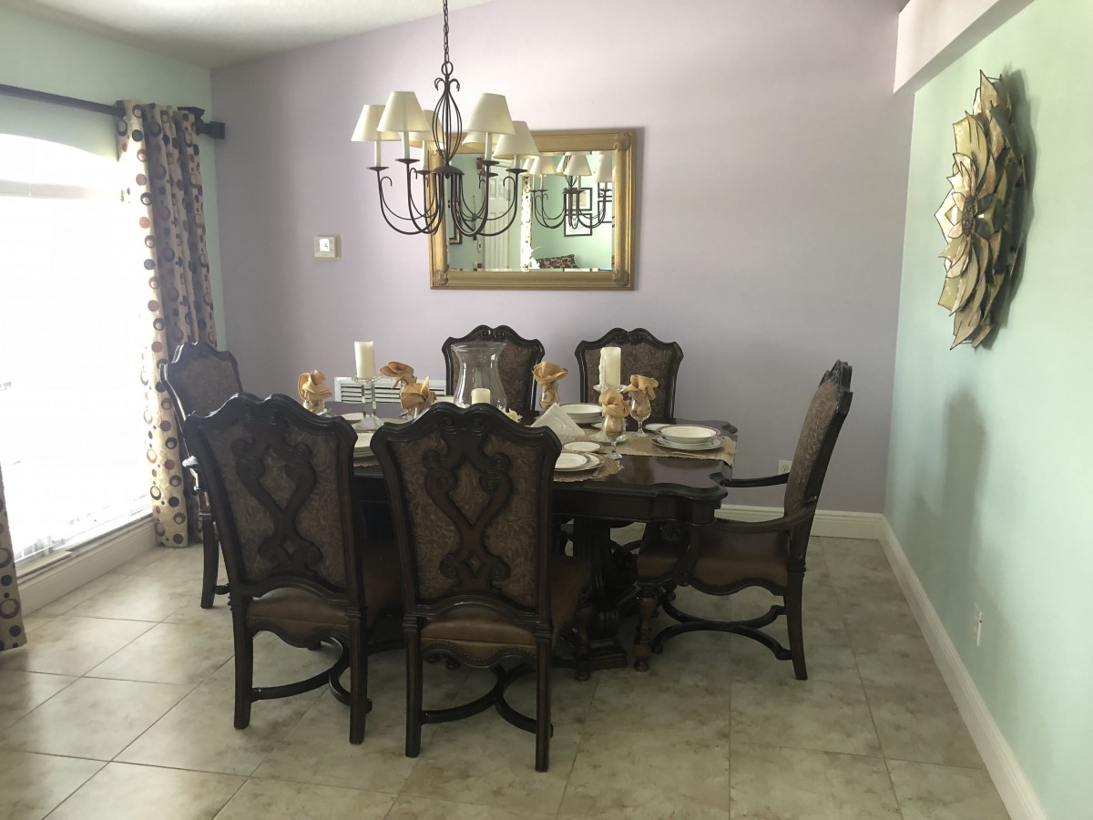 A well-decorated dining room with a large table, chairs, and a chandelier.