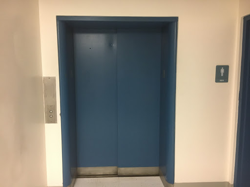 A blue elevator door in a hallway.