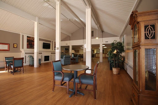 A spacious and inviting lounge area featuring comfortable seating and a warm wooden floor.