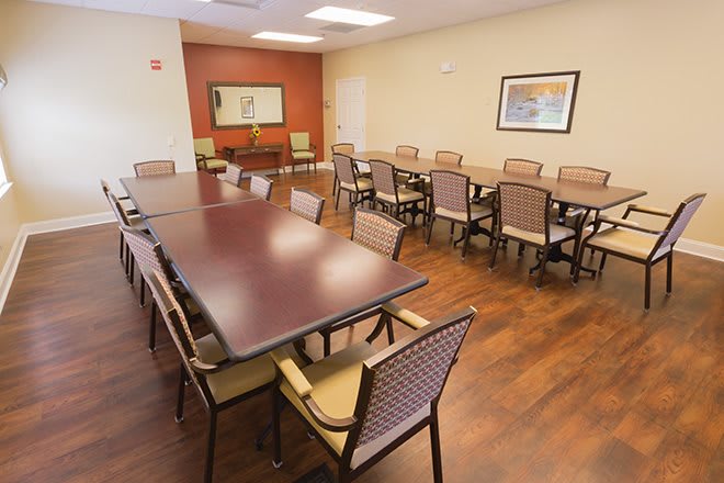 An empty conference room with long tables and chairs arranged neatly.