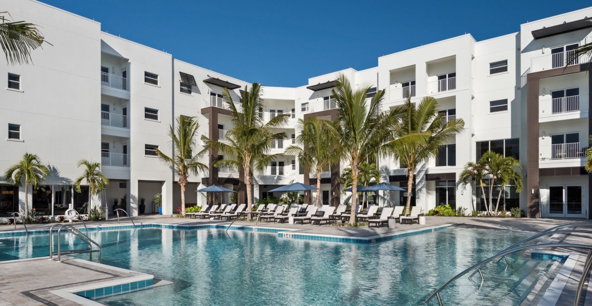 A luxurious hotel with a pool and palm trees, perfect for a vacation.
