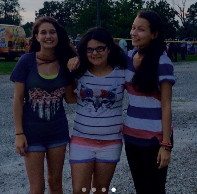 Three friends enjoying an evening outdoors together.